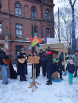 Śpiewanie kolęd przy szopce na zewnątrz kościoła